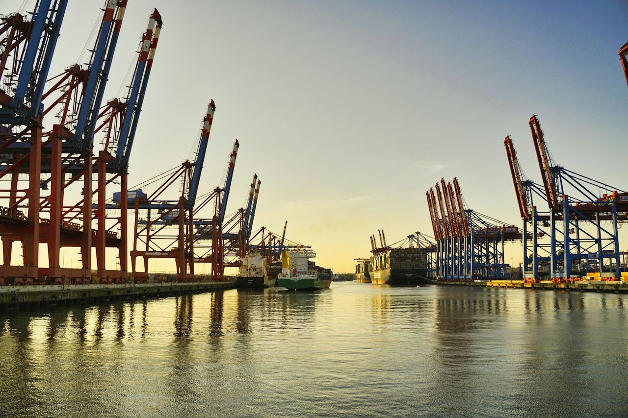 Container port cranes at sunset